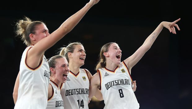 PARIS, FRANCE - AUGUST 05: Marie Reichert #6, Sonja Greinacher #14, Svenja Brunckhorst #21 and Elisa Mevius #8 of Team Germany celebrate after their victory against Spain during a Women's 3x3 basketball Gold medal game between Germany and Spain on day ten of the Olympic Games Paris 2024 at Esplanade Des Invalides on August 05, 2024 in Paris, France. (Photo by Matthew Stockman/Getty Images)